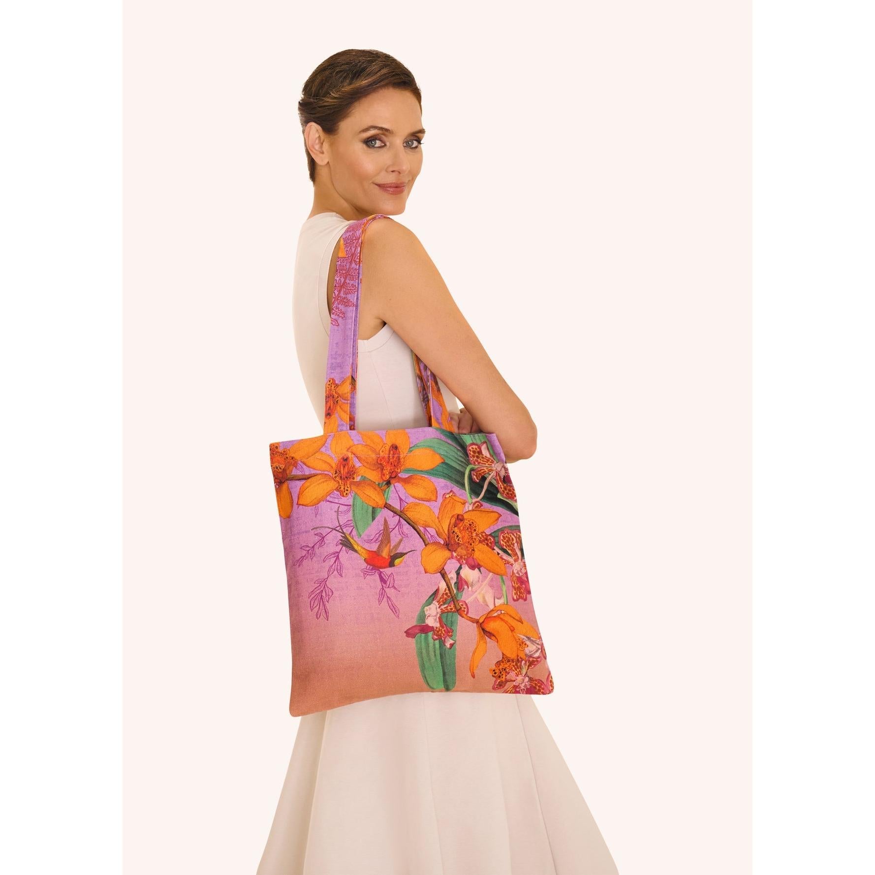 Powder Botany Bliss lavender canvas tote bag with floral prints, carried by a woman in white dress.