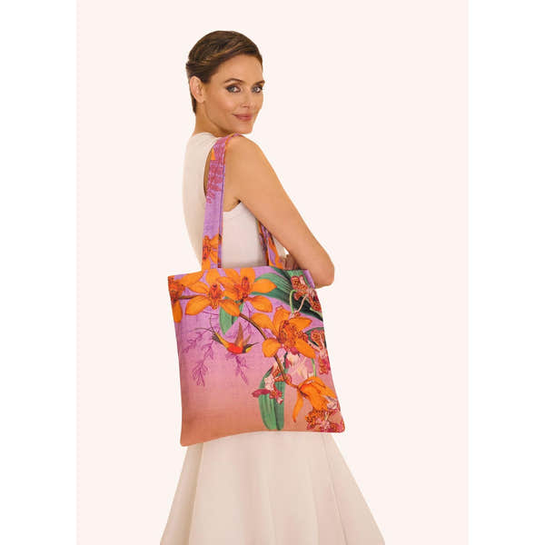 Powder Botany Bliss lavender canvas tote bag with floral prints, carried by a woman in white dress.