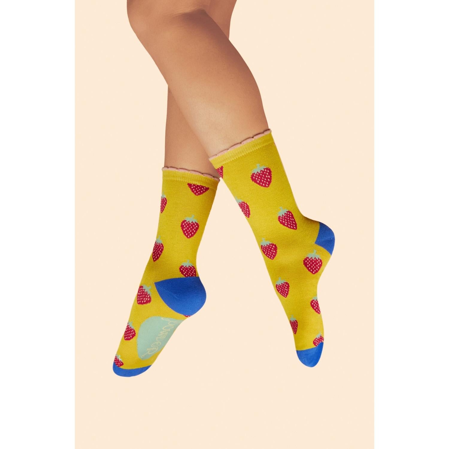 Powder yellow ankle socks with strawberry pattern, blue heel and toe accents, and 