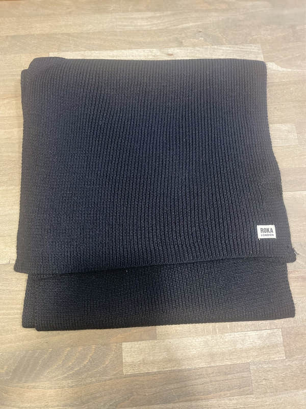 ROKA London Hyde Black Scarf, ribbed knit, stylish and warm, men's accessory, folded on wooden surface.