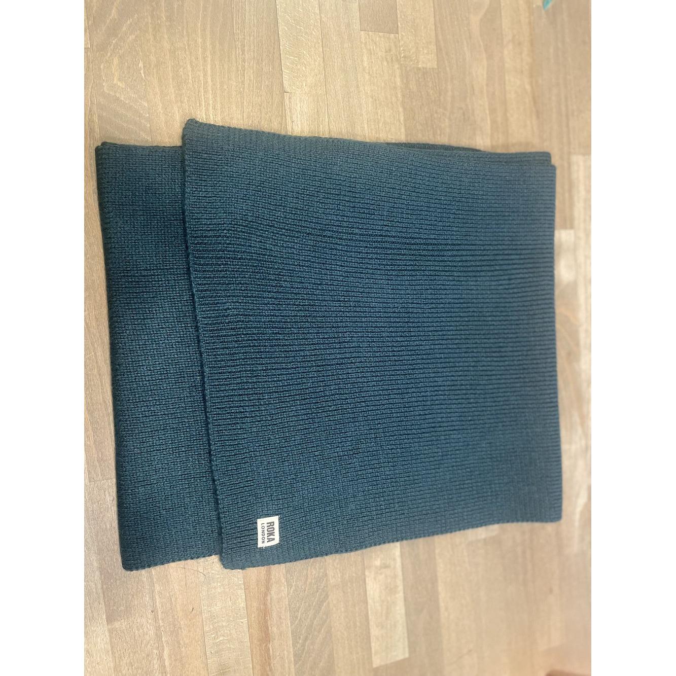 ROKA London Hyde Midnight Scarf, dark blue ribbed knit fabric, lightweight and cozy, with ROKA logo tag, ideal for cold weather.