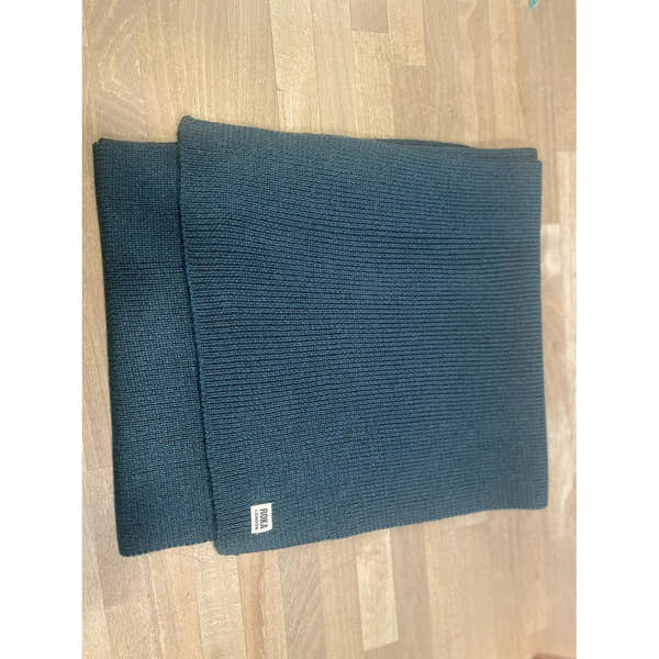 ROKA London Hyde Midnight Scarf, dark blue ribbed knit fabric, lightweight and cozy, with ROKA logo tag, ideal for cold weather.
