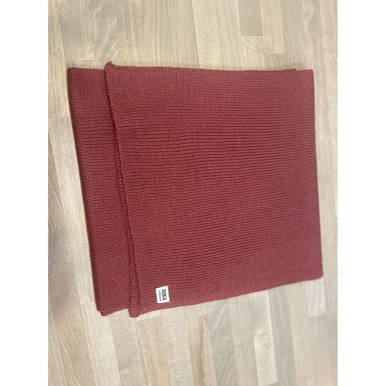 ROKA London Hyde Plum Scarf, folded red knit scarf with small white logo tag, cozy and stylish accessory for cold weather.