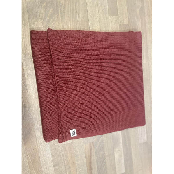 ROKA London Hyde Plum Scarf, folded red knit scarf with small white logo tag, cozy and stylish accessory for cold weather.
