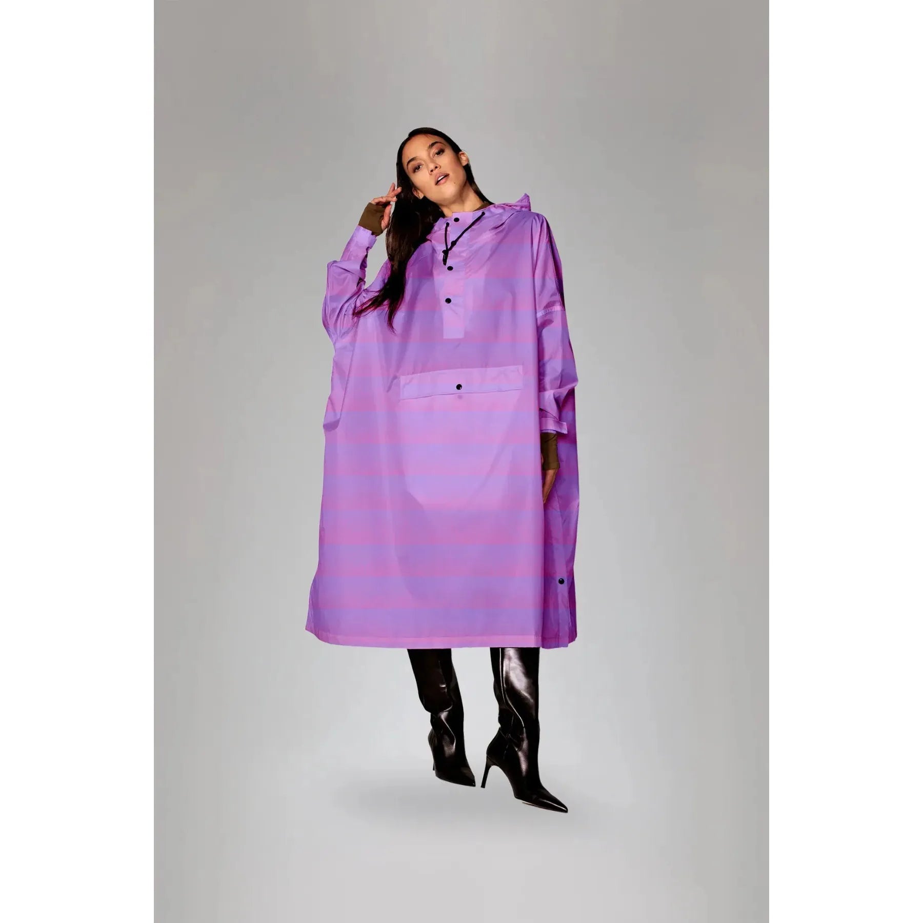 Rainkiss Seeing Stripes Purple Rain Poncho worn by a model, featuring a purple rain-themed design and button details, full-length style.