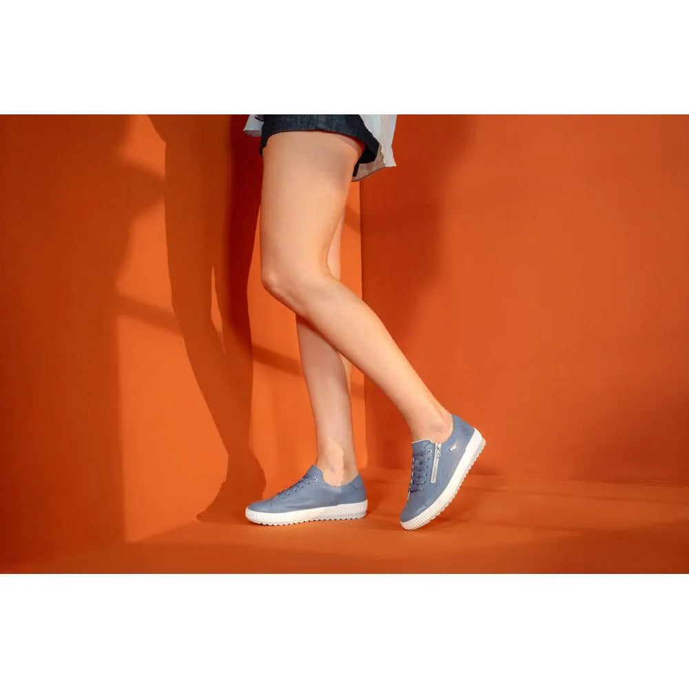 Light blue leather zip and lace shoes with a white sole, showcased against a vibrant orange background.