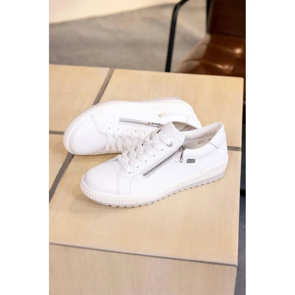White leather lace-up shoes with a zip detail, water-resistant, casual style on a wooden surface.