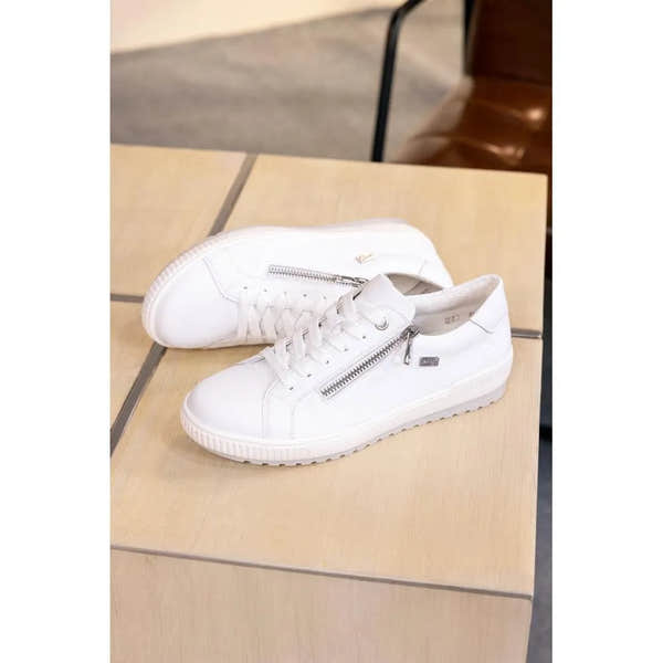 White leather lace-up shoes with a zip detail, water-resistant, casual style on a wooden surface.