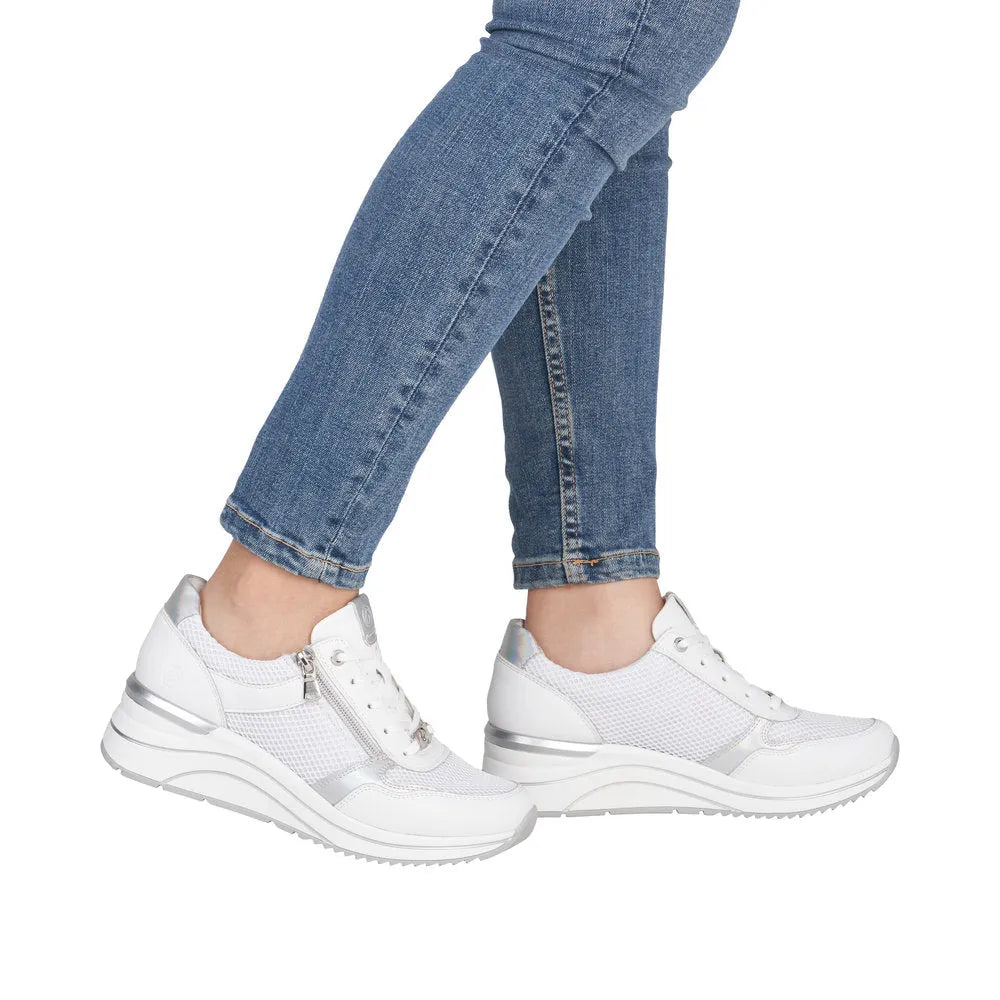 White leather zip and lace trainers with mesh detailing and silver accents, styled with blue jeans.