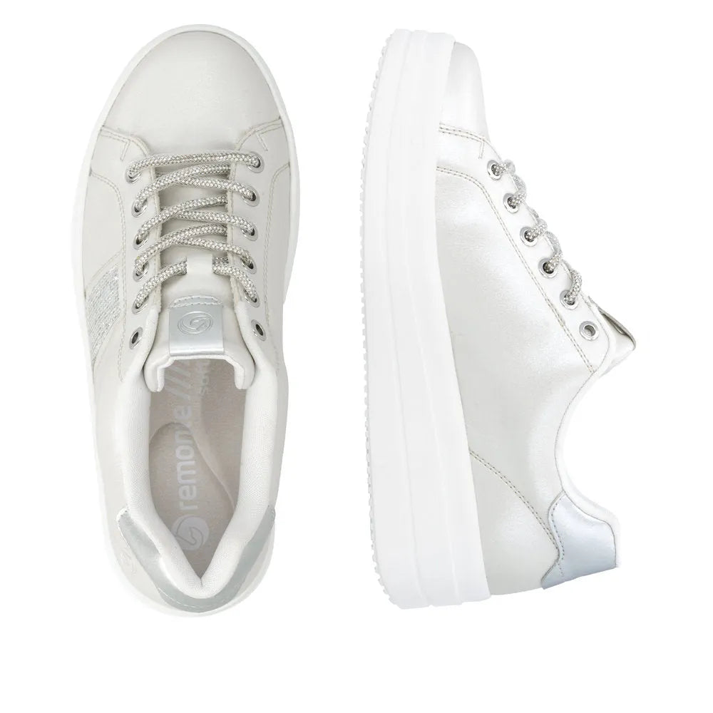 Off-white/silver vegan elasticated ladies sneakers with laces, metallic accents, and a thick white sole.