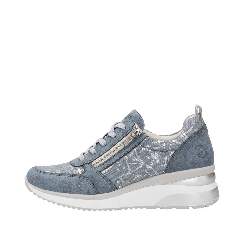 Blue textile sneaker with side zipper, lace-up front, and white sole featuring a curved heel design.
