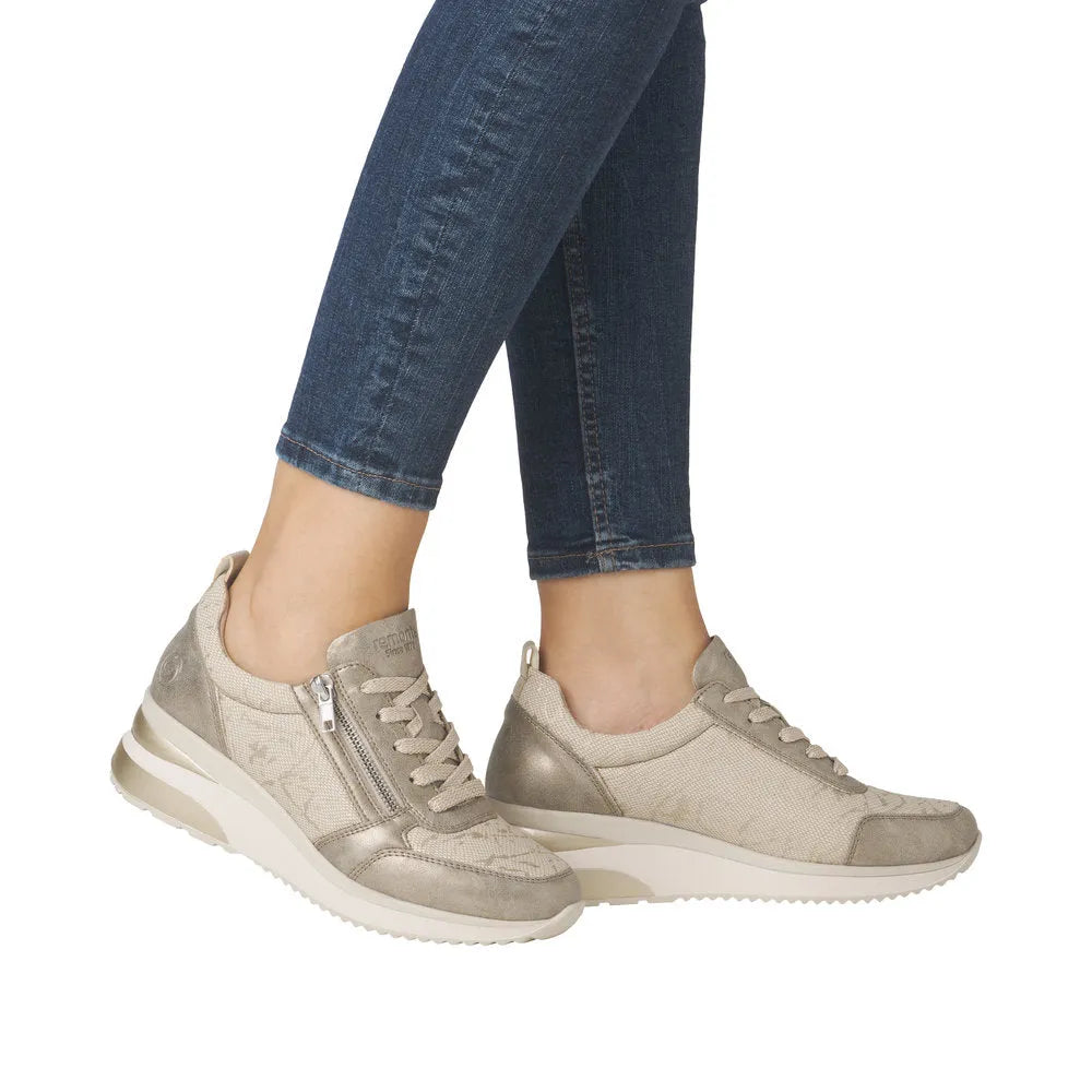 Ladies cream textile sneakers with side zipper, metallic accents, and white rubber soles.