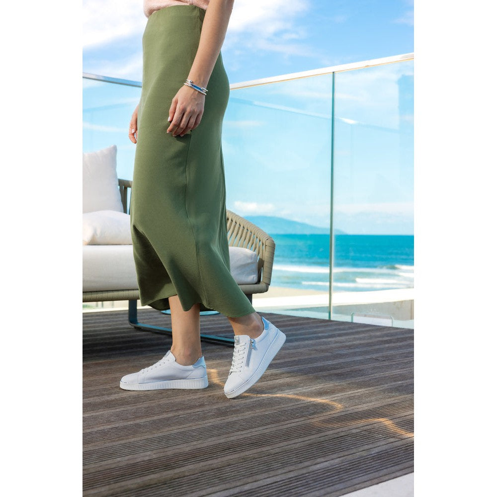 Remonte D2E01-80 women's white leather trainers with zip and lace-up details, wide fit, stylish casual footwear, ocean view background.
