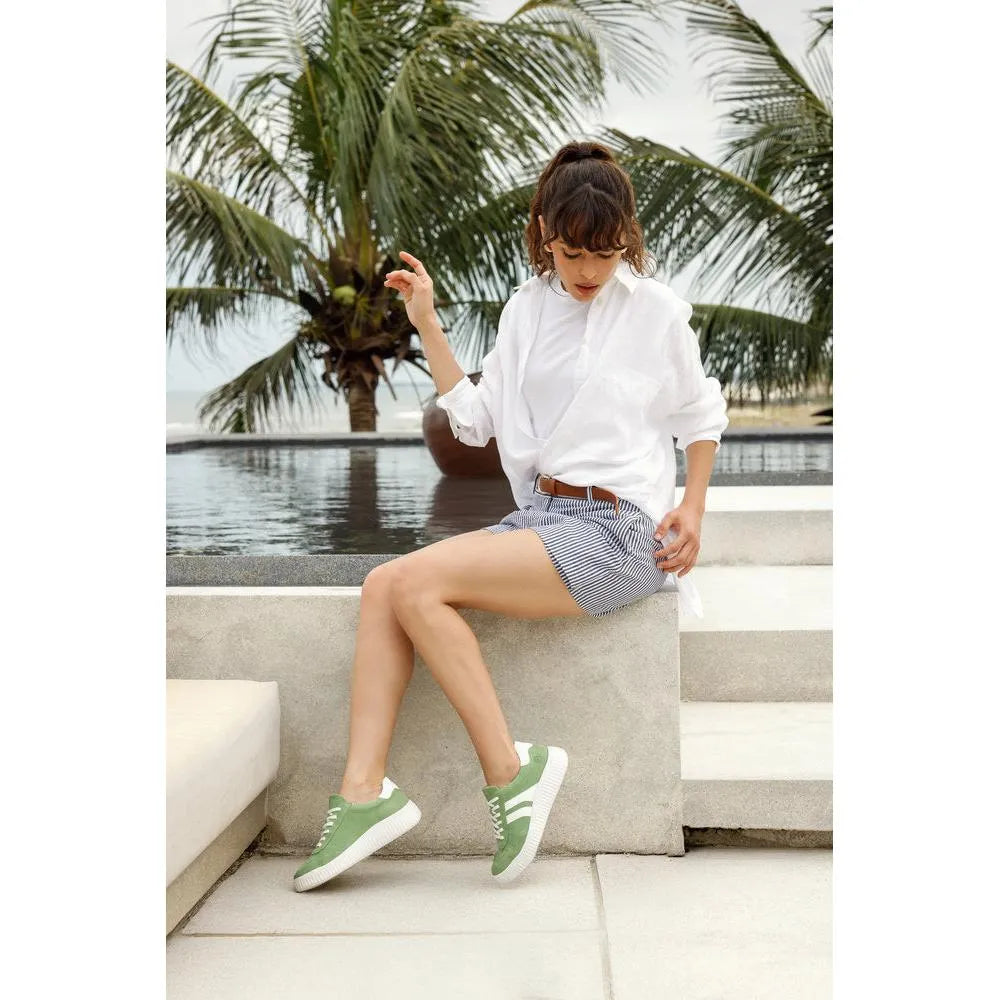 Women’s wide green suede lace-up shoes with white soles and stylish design.