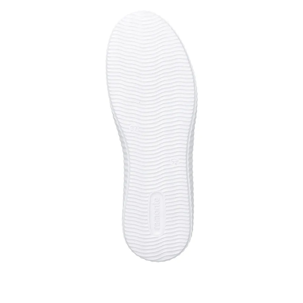 White sole of green suede lace-up shoe with textured tread design and 