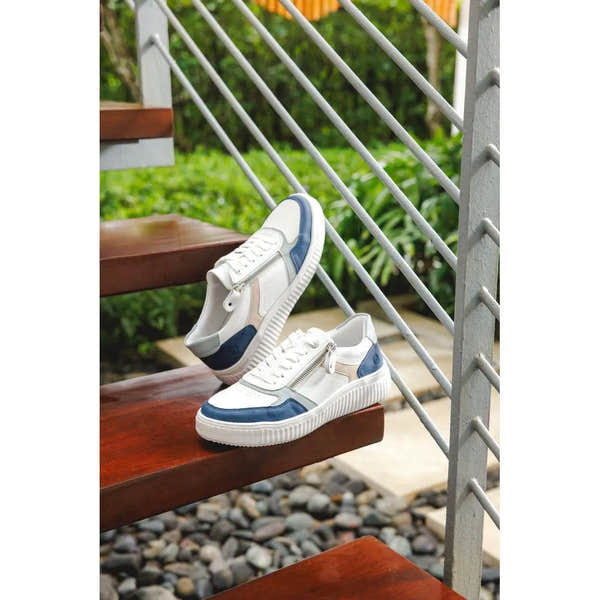 White and navy leather lace-up sneakers with side zippers and a striped rubber sole.