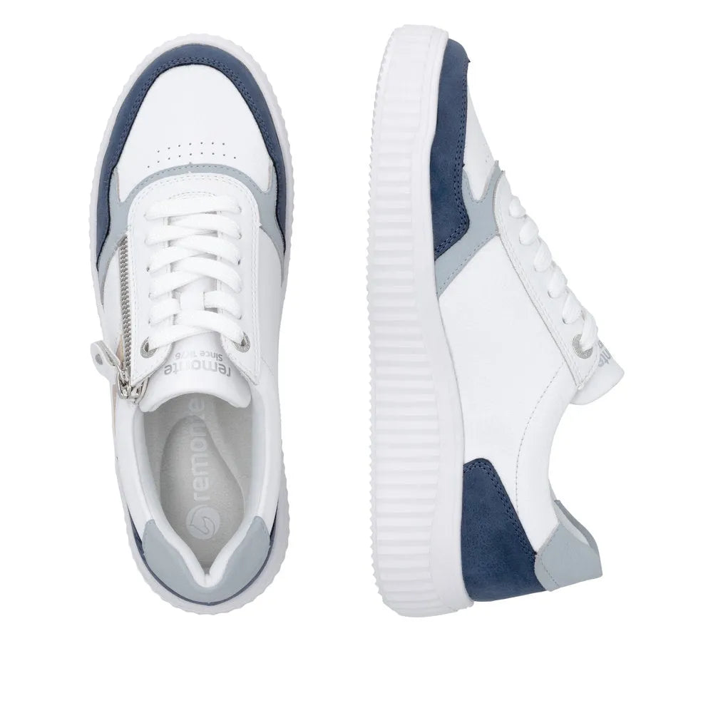 White and navy leather women's sneakers with lace-up and zipper detail, chunky white sole, and wide fit.