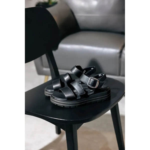 Remonte D3N50-00 Women's black leather touch-fastening sandals with thick platform sole, on black chair.
