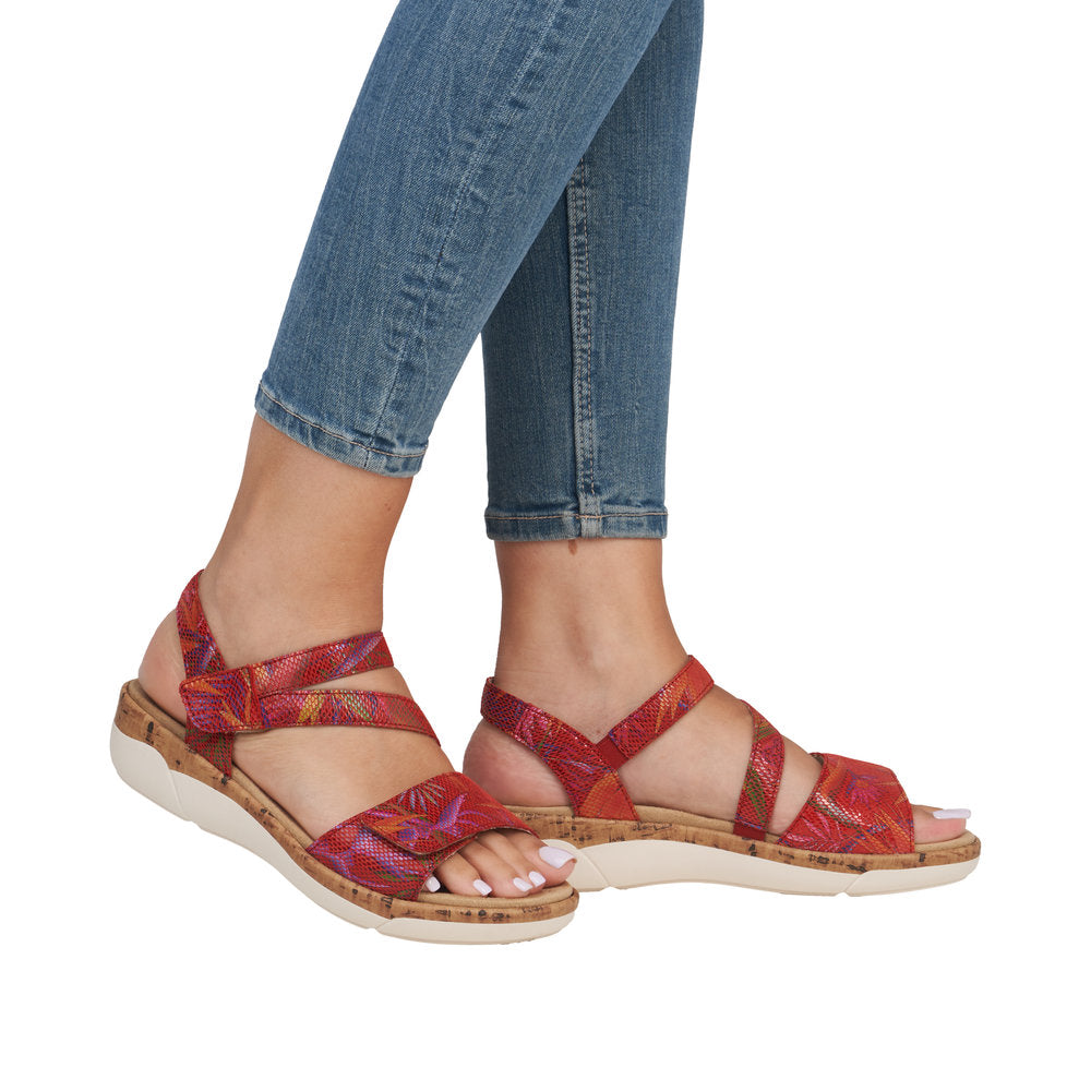 Red women's leather touch fastening sandals with colorful patterned straps and cork sole, casual summer footwear.