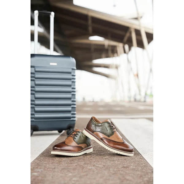 Rieker 04504-91 men's wide brown and green leather lace-up shoes with brogue detailing and white soles.