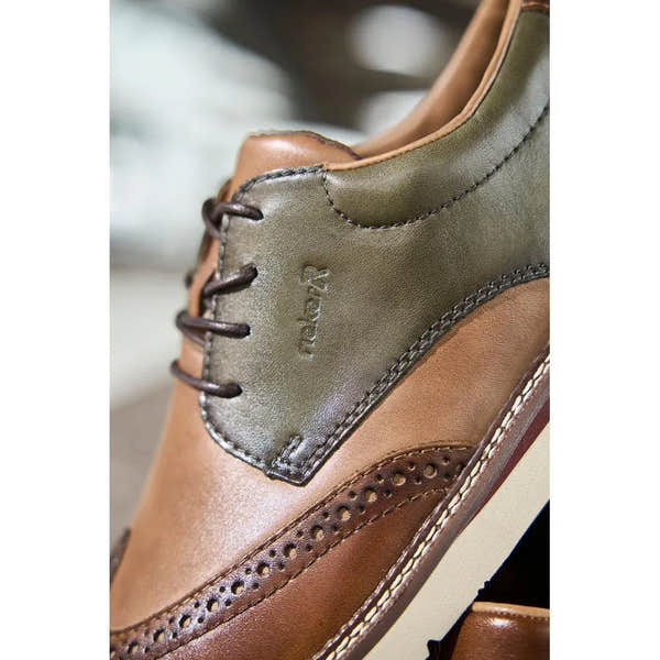 Brown and green leather lace-up shoes with brogue detailing, wide fit, and stitched accents.