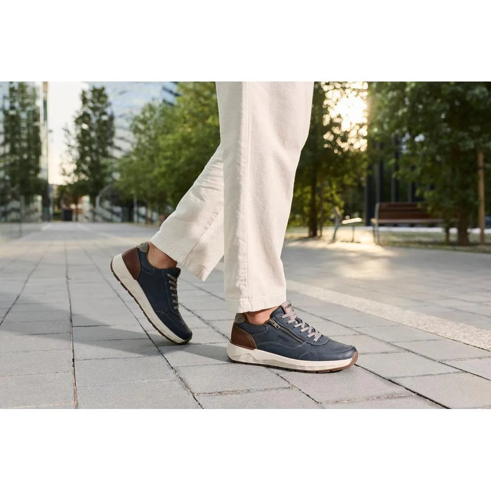 Rieker 11504-14 men's wide navy shoes with brown accents, zip and lace closure, rubber sole, in an outdoor urban setting.
