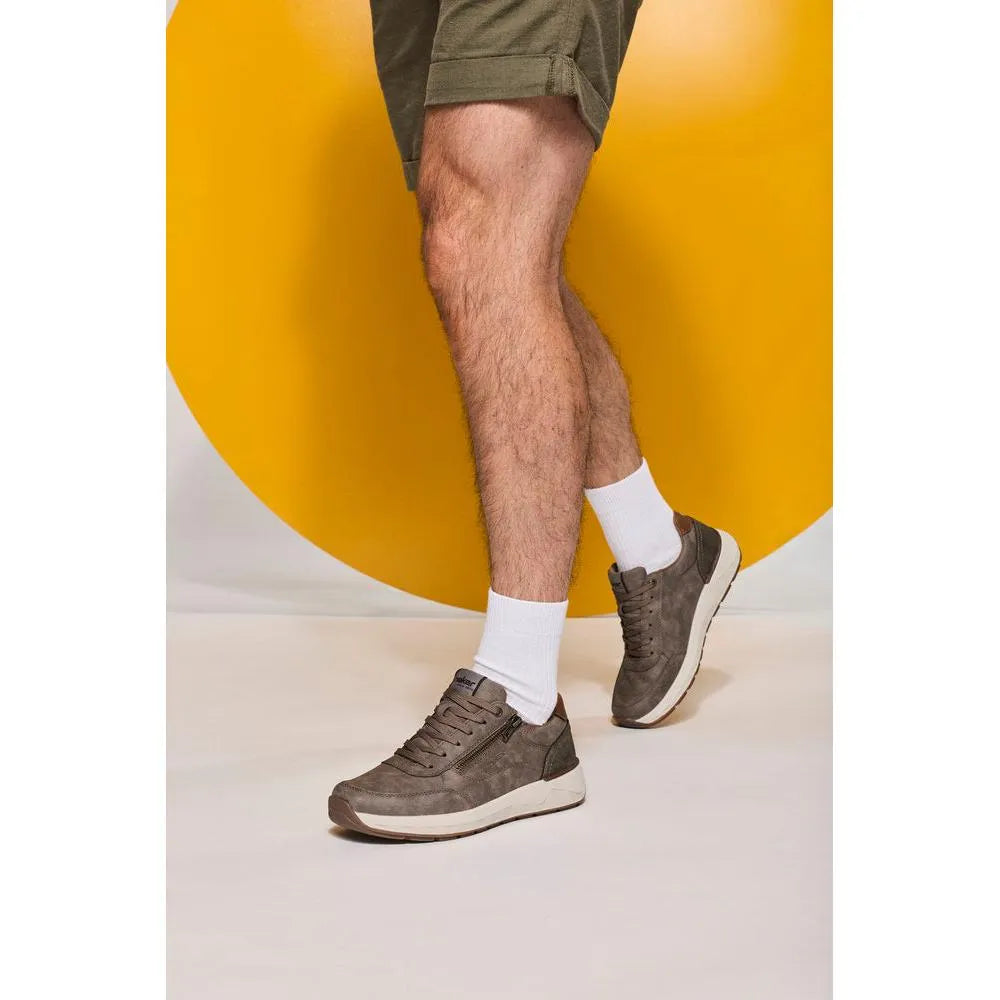 Men's wide brown zip and lace casual shoes with suede material, padded collar, and white sole, worn with white socks.