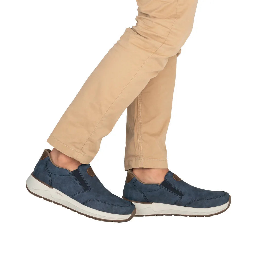 Men's wide slip-on denim blue shoes with brown accents and white soles, casual slip-on style.