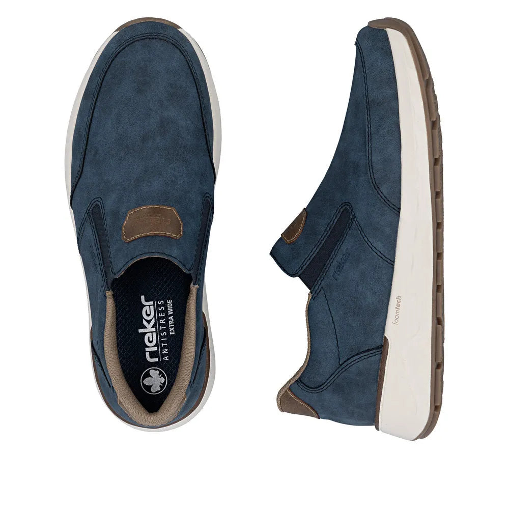 Blue denim-style slip-on shoes for men with brown accents, white sole, and foamtech cushioning, wide fit.