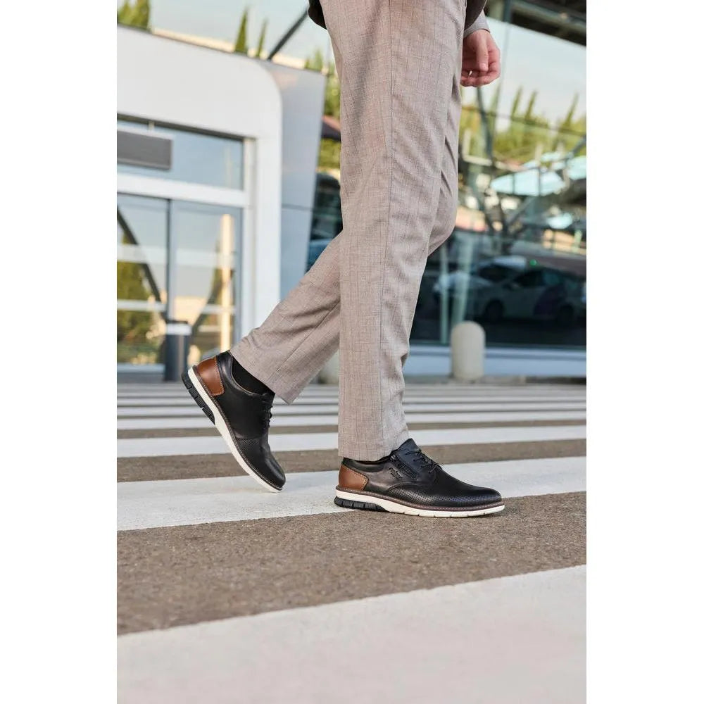 Men's black leather shoes with brown accents, lace-up and zip closure, sporty sole, worn with beige trousers.