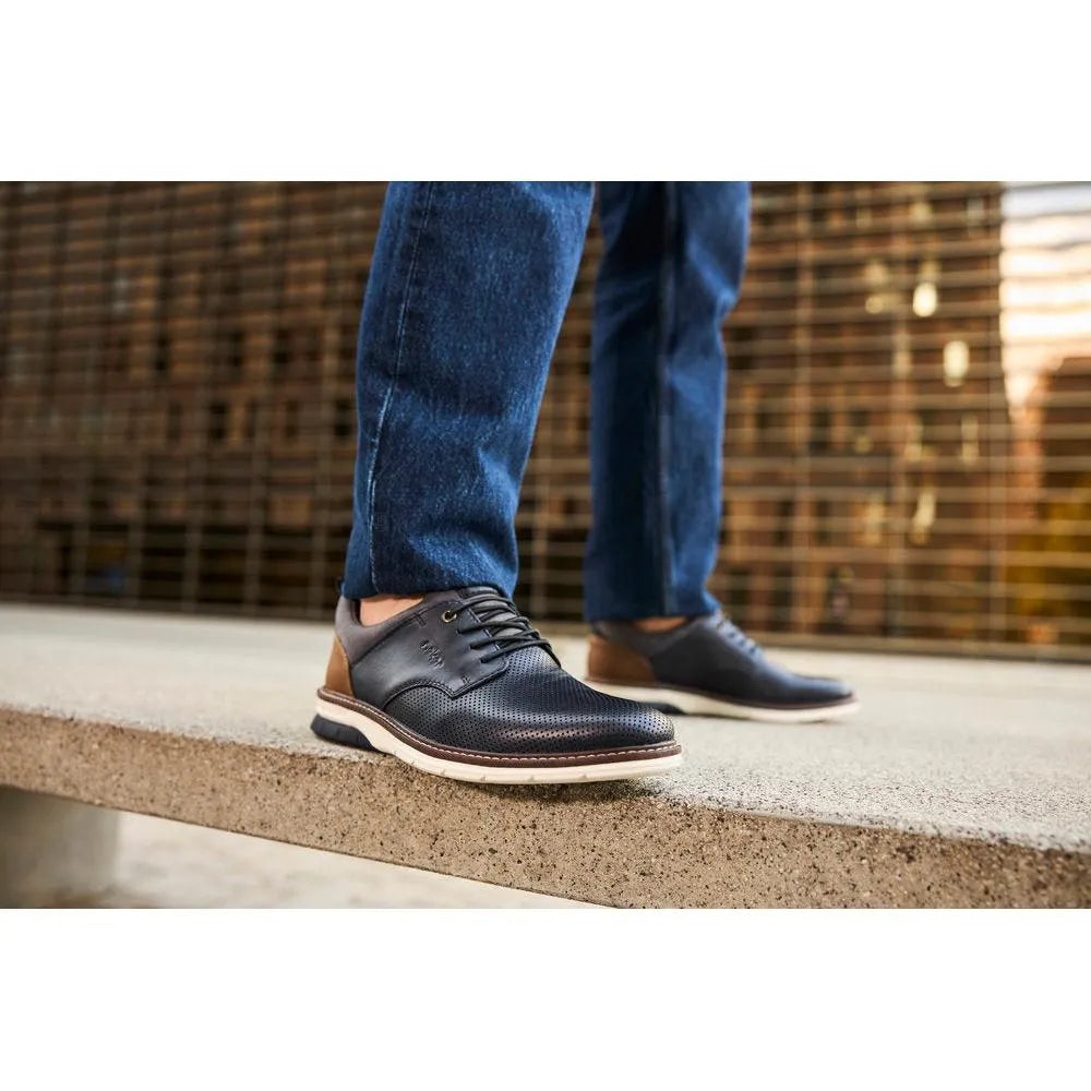Rieker 14450-15 men's navy and brown leather slip-on dress shoes with perforated design and white soles.