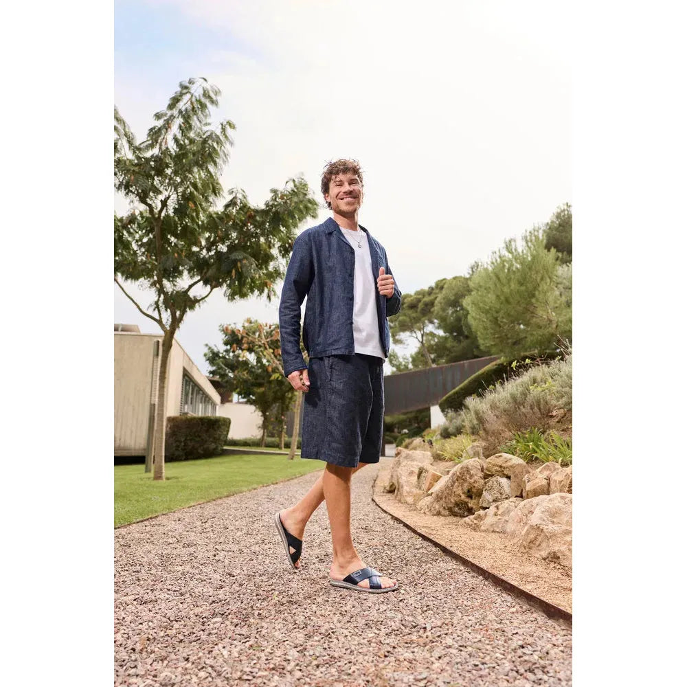 Rieker 21082-14 men's wide-fit navy and grey leather elasticated slip-on mules in an outdoor setting.