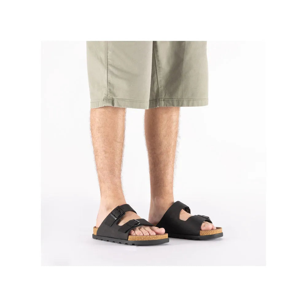 Rieker 21190-00 men's wide fit black suede buckle mule sandals with cork footbed and rugged outsole.