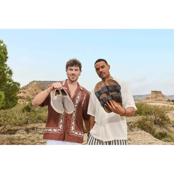 Men's wide-fit grey suede buckle mule shoes, casual footwear for outdoor adventures, showcased by two men outdoors.