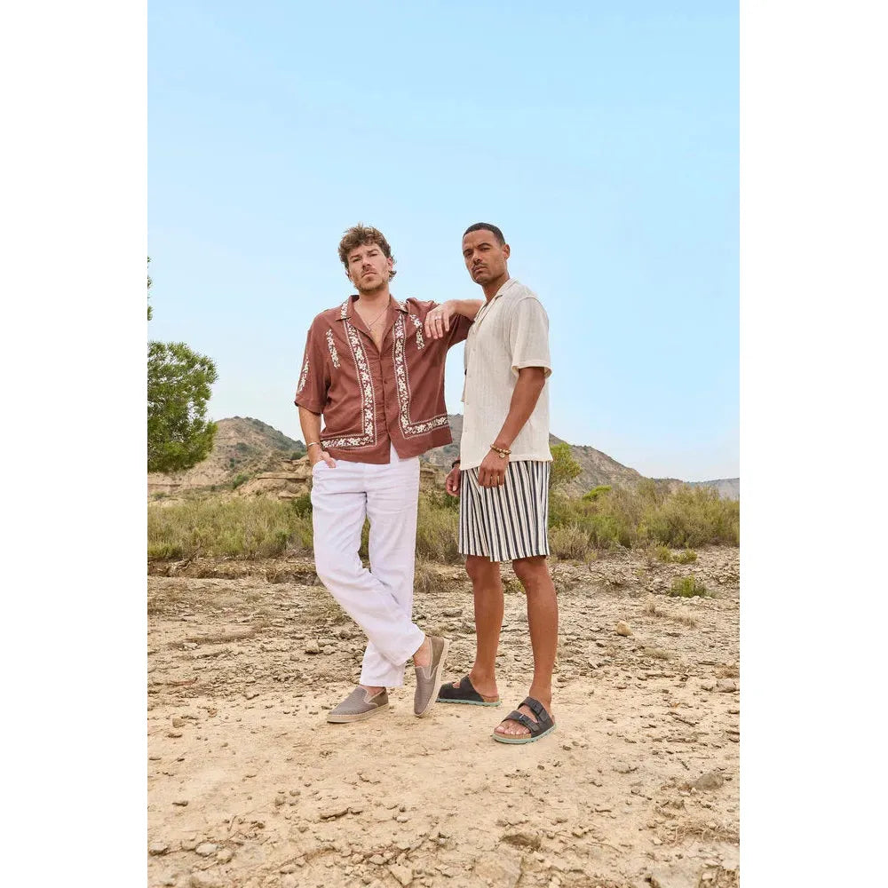 Rieker 21190-45 men's wide-fit grey suede buckle mules, casual summer footwear, styled for outdoor warm weather.