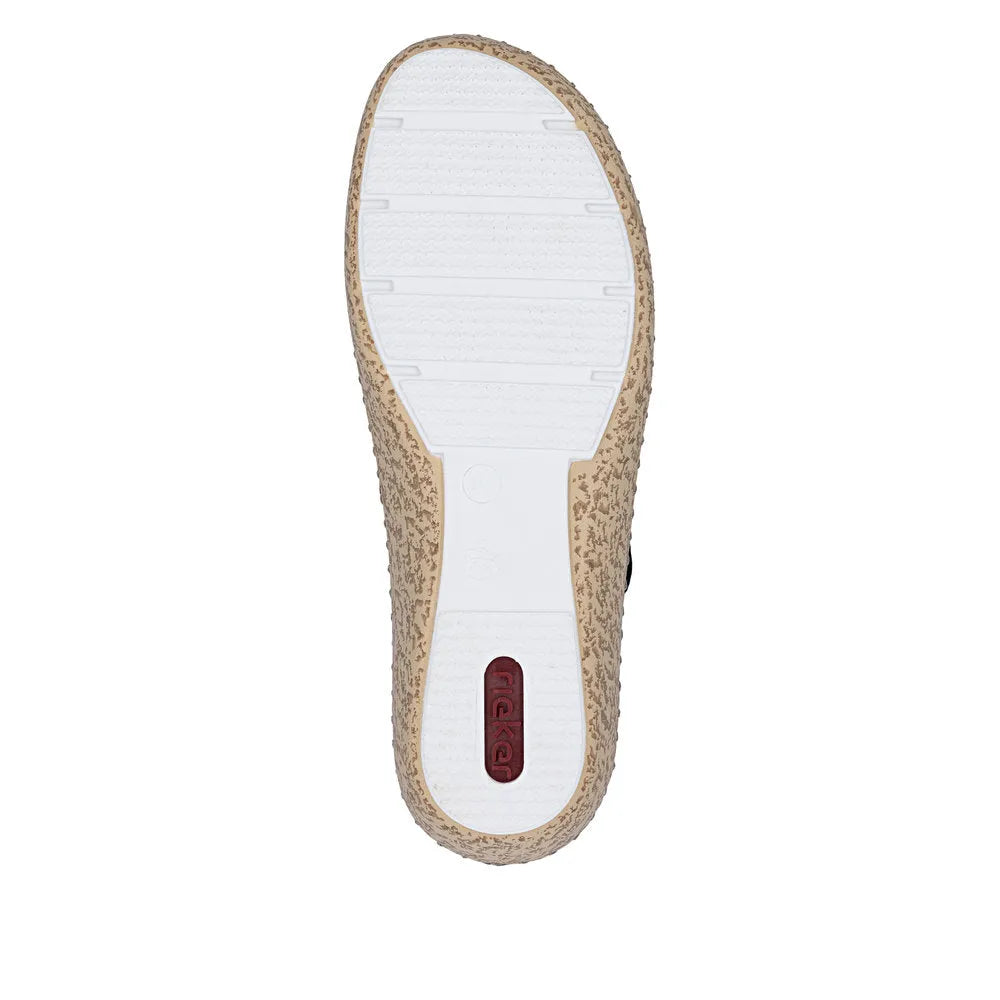 White and beige textured slip-on shoe with touch fastenings, sole with grip pattern, and Rieker branding on heel.