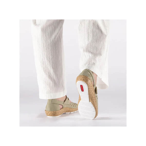 Rieker 44872-52 ladies green touch fastening shoes with leather upper, cork sole, and ankle strap, worn with off-white textured pants.