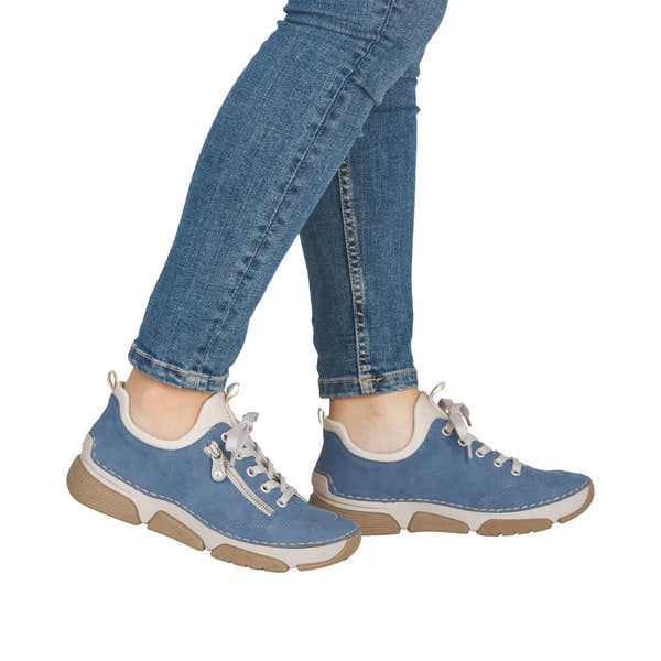 Light blue lace-up shoes with white accents, beige soles, and side zippers, worn with skinny jeans.