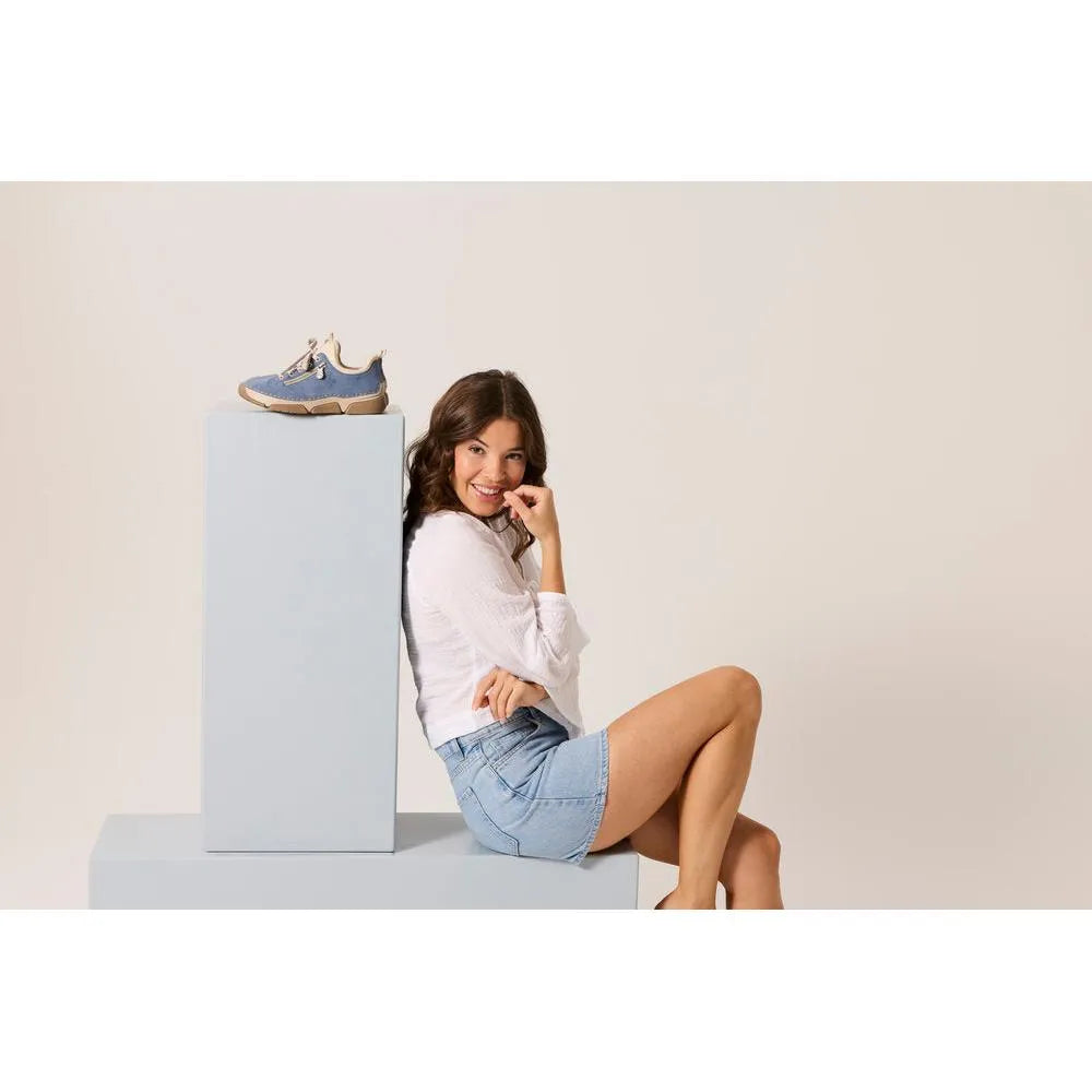 Light blue lace-up ladies' shoes with suede and mesh materials, chunky soles, and beige accents, displayed on a pedestal.