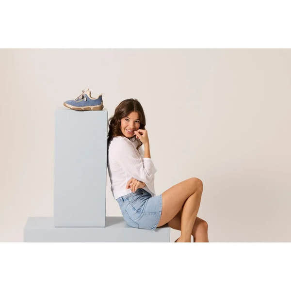 Light blue lace-up ladies' shoes with suede and mesh materials, chunky soles, and beige accents, displayed on a pedestal.