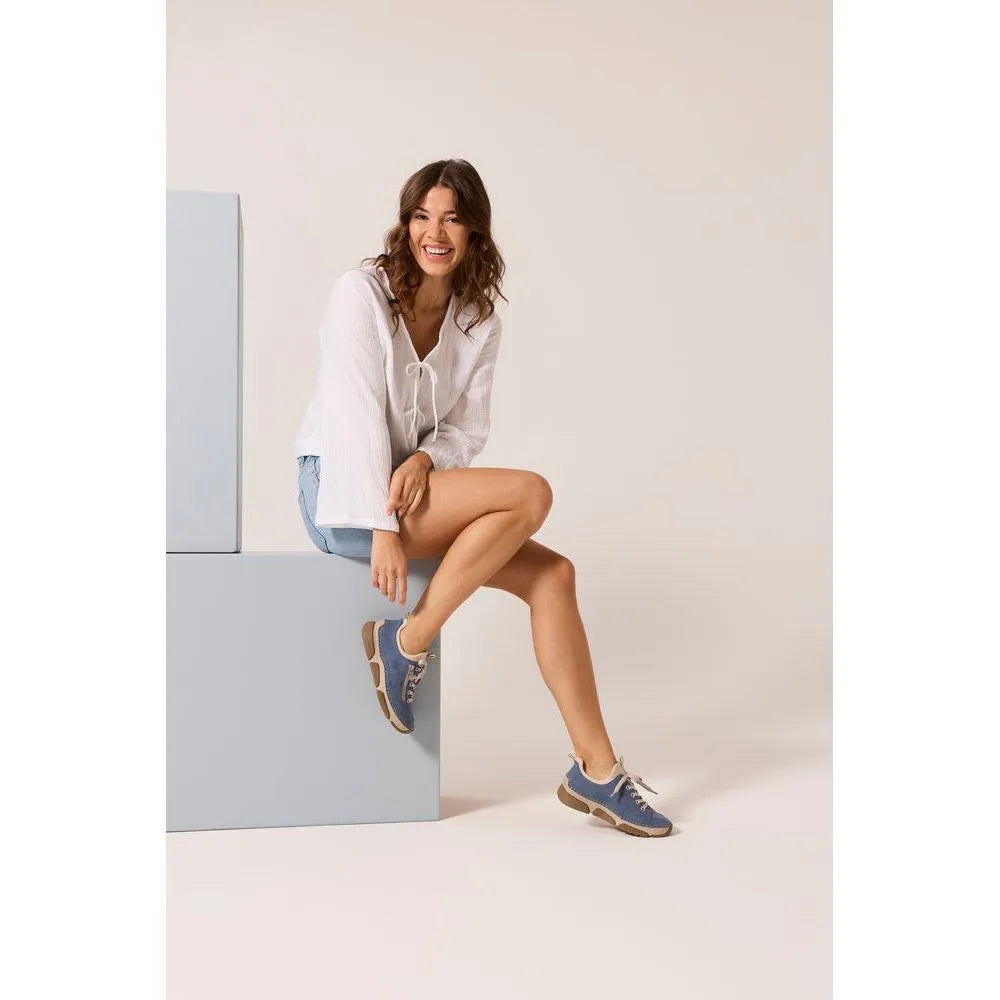 Light blue Rieker 45973-14 lace-up shoes with breathable material and beige soles, worn casually by a smiling woman.