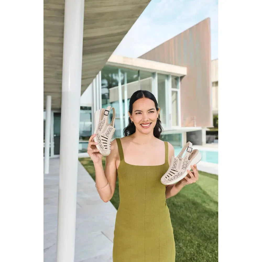 Rieker 48763-60 women's cream leather slingback sandals, with perforated design and adjustable buckle strap, outdoor setting.