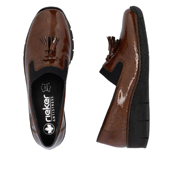 Rieker 53751-24 women's brown slip-on shoes with tassel detail, elastic side panels, and cushioned sole.