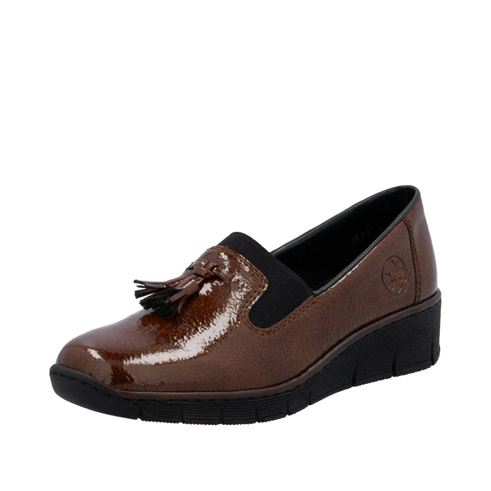 Rieker 53751-24 women's brown slip-on shoes with tassel detail, textured finish, and low heel, ideal for comfortable casual wear.