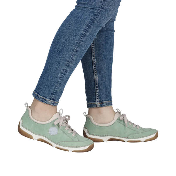 Mint green lace-up casual shoes with beige lining and brown rubber soles, worn with blue jeans.