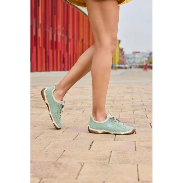 Mint lace-up casual shoes with suede and textile materials, white accents, and gum soles worn by a person outdoors.