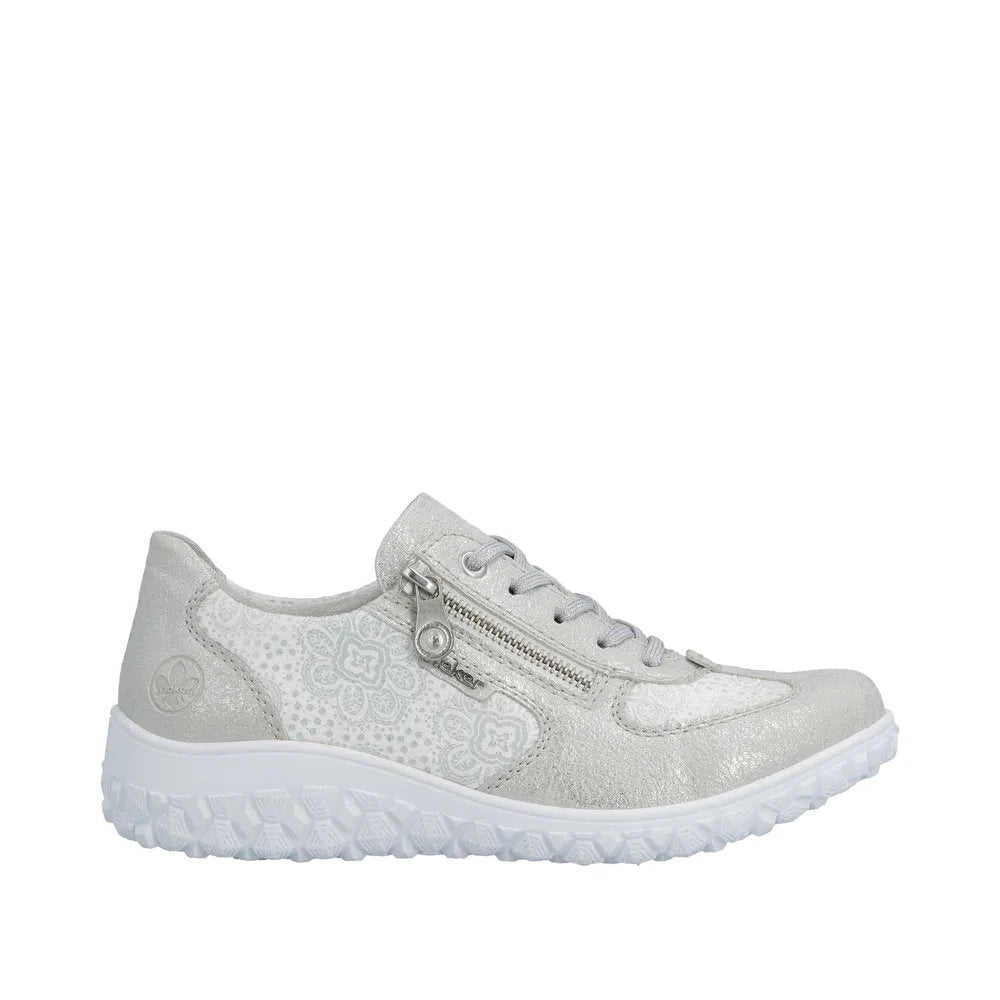 Rieker 59501-90 women's wide fit white and silver lace-up shoe with side zipper, floral pattern, textured sole, and metallic accents.
