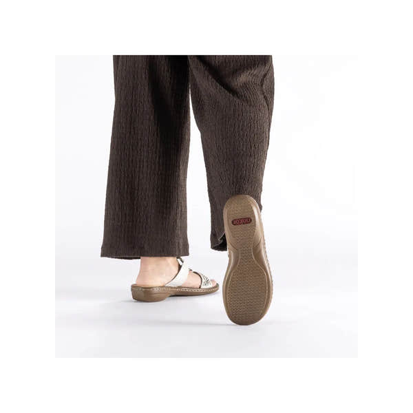 Rieker 608K2-40 women's silver touch-fastening mule shoes with open toe and low heel, displayed on a person wearing dark wide-leg pants.