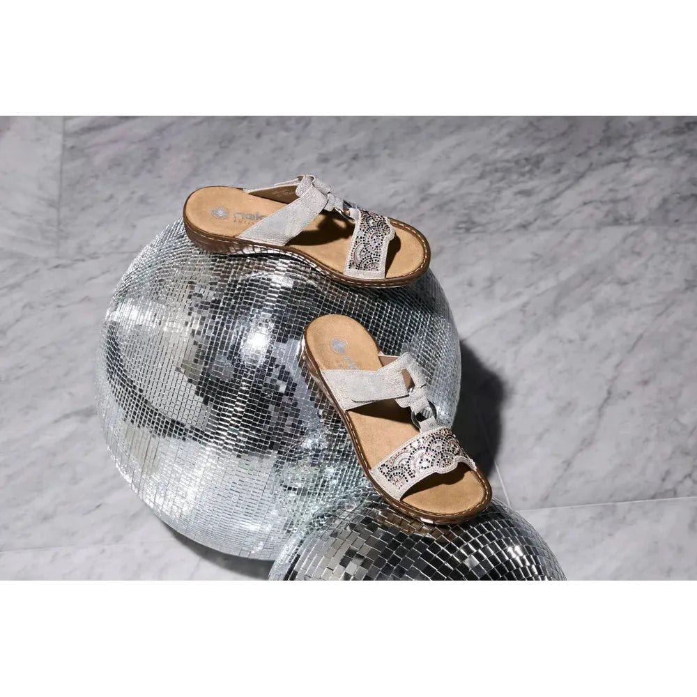 Ladies silver touch fastening mule sandals with decorative beadwork, placed on disco ball decor.