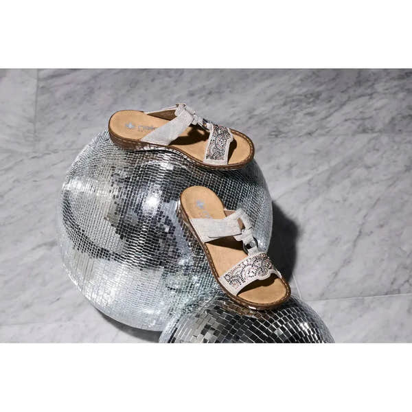 Ladies silver touch fastening mule sandals with decorative beadwork, placed on disco ball decor.